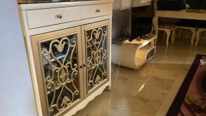 a white cabinet with ornate metal doors in a room at Apartment Zayed moon-trip in Sheikh Zayed