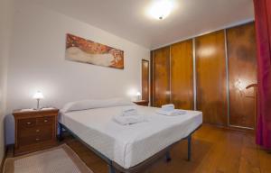 a bedroom with a bed and a wooden cabinet at Fishermans Cottage in Lagos in Lagos
