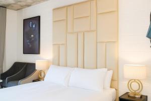 a bedroom with a white bed with a wooden headboard at Oceanfront Bliss with Breathtaking Views in Cape Town +33 photos