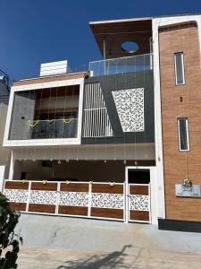 マイソールにあるSamruddhi Hill View Homestayの白い柵の建物