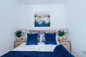Un dormitorio con una cama con almohadas azules. en 3Bed House-10 Mins to Liverpool, en Bidston