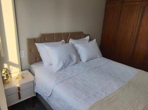 a bedroom with a bed with white sheets and pillows at Flat Mar Premium 1408 in Fortaleza