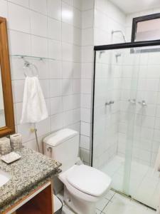 a bathroom with a toilet and a glass shower at Flat Mar Premium 1408 in Fortaleza
