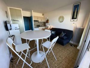 ein Wohnzimmer mit Tisch und Stühlen und einer Couch in der Unterkunft Résidence Cap Atlantic - 024 - Appartement avec belle terrasse et vue imprenable sur l'Océan MAE-1951 in Soulac-sur-Mer