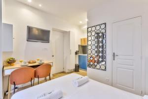 a room with a bed and a table and chairs at Charmant studio au coeur des Batignolles in Paris