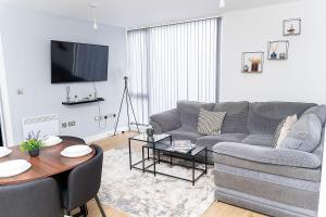 una sala de estar con un sofá y una mesa en 2 Bed Deluxe Apt City Centre, Long stay, en Mánchester