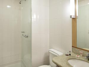a bathroom with a shower and a toilet and a sink at ibis Curitiba Shopping in Curitiba