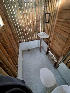 a small bathroom with a sink in a wooden cabin at Siwi Lodge in Cañaveral