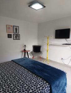 une chambre avec un lit, une télévision et une chaise dans l'établissement Casa Bom Viver, à Arraial do Cabo