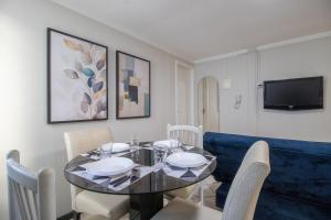 comedor con mesa y sofá azul en CLR81 - Calçadão, 1 Dorm Climatizado, Garagem, en Balneário Camboriú