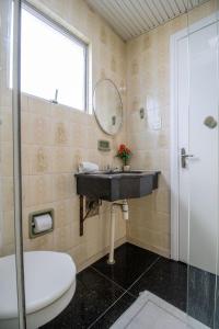 Un baño con lavabo, espejo e inodoro. en CLR81 - Calçadão, 1 Dorm Climatizado, Garagem, en Balneário Camboriú 28 fotos más
