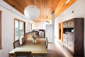 a dining room with a wooden table and a kitchen at Ocean Vista In the Woods on Saltspring Island in Salt Spring Island