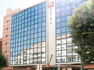 a large glass building with a sign on it at ibis Issy les Moulineaux "Val de Seine" in Issy-les-Moulineaux