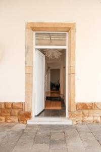 une porte ouverte d'un bâtiment blanc avec un couloir dans l'établissement Kuschelkoje - Ihr gemütliches Ferienzuhause in der Pfalz, à Diedesfeld