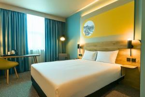 a hotel room with a large bed and a desk at B&B HOTEL Derby in Derby