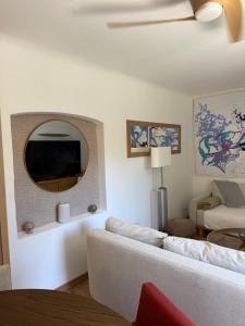 a living room with a white couch and a mirror at Lorette Hideway in Saint-Tropez