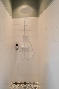 a bathroom with a shower with a glass shower head at Stylish Apartment in Historic Villa Doll, City Center in Viljandi