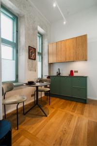 a kitchen with green cabinets and a table and chairs at Stylish Apartment in Historic Villa Doll, City Center in Viljandi