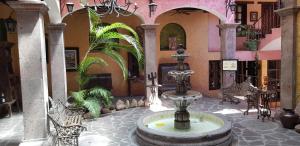 une cour avec une fontaine dans un bâtiment dans l'établissement Posada de las Flores Loreto, à Loreto