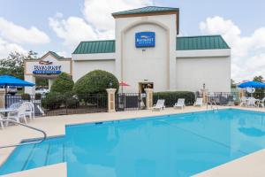 einen Pool vor einem Hotel mit Restaurant in der Unterkunft Baymont by Wyndham Greensboro/Coliseum in Greensboro