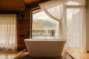 卡兹贝吉Rookhe Kazbegi的带窗户的房间里的浴缸