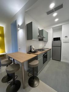 a kitchen with a wooden table and stools at Dimore di Baia in Bacoli