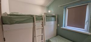 a small room with two bunk beds and a window at Casa Gaumaise - climatisation réversible et nature in Virton