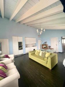 a living room with a green couch and white furniture at Views on Venice Lagoon in Lido