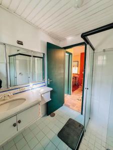 a bathroom with a sink and a shower with a mirror at Cabana Catuaí - com piscina privativa in Paiol Grande
