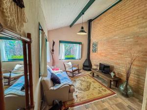 a room with a bed and a brick wall at Cabana Catuaí - com piscina privativa in Paiol Grande