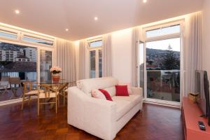 a living room with a white couch and a table at BJ Apartments Funchal in Funchal