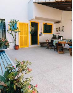 un patio avec une porte jaune et une table dans l'établissement Casa Bom Viver, à Arraial do Cabo