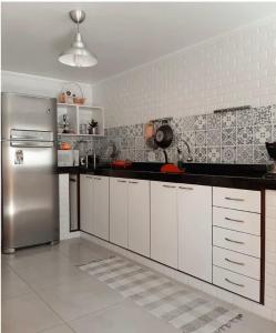 eine Küche mit weißen Schränken und einem Edelstahlkühlschrank in der Unterkunft Casa Bom Viver in Arraial do Cabo + 34 Fotos