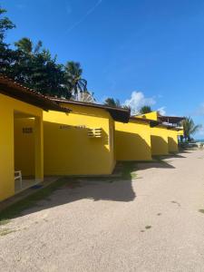 a row of yellow buildings on the beach at Casa a beira Mar - Ponta de Mangue - Maragogi in Maragogi +13 photos