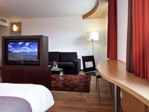 ein Hotelzimmer mit Bett und Fernseher in der Unterkunft ibis Delémont in Delémont