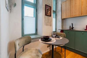 a kitchen with a table and chairs in a kitchen at Stylish Apartment in Historic Villa Doll, City Center in Viljandi +14 photos