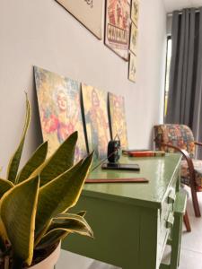 un bureau vert avec une plante en pot dans une pièce dans l'établissement Casa Bom Viver, à Arraial do Cabo