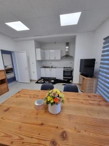 una mesa con un jarrón de flores encima en Sobe Kod Ćobe, en Matuzići