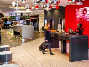 Una mujer pasa junto a un mostrador en una tienda. en ibis London Blackfriars, en Londres
