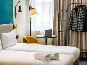 a hotel room with two beds and a laptop on a table at ibis London Blackfriars in London