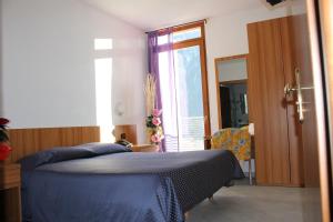 ein Schlafzimmer mit einem blauen Bett und einem Fenster in der Unterkunft Hotel Rezia in Sondalo