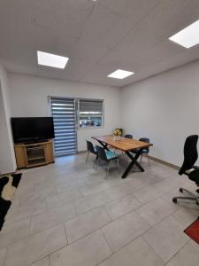 an office with a table and chairs and a television at Sobe Kod Ćobe in Matuzići