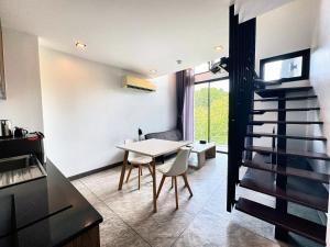a kitchen and dining room with a table and chairs at Utopia Loft Condo Naiharn Beach in Nai Harn Beach