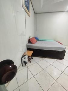 a small room with a bed and a chair at Pousada Nova Jerusalém in Cianorte +1 photo