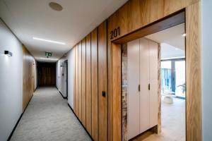 a hallway with wood paneling and a hallway with doors at Vidok 201 in Olsztyn