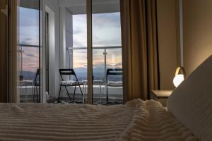 a bedroom with a bed and a view of a balcony at Golden-Hour Loft 35F Sunset Views Free Parking in Gorno Lisiče +19 photos