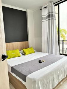 a bedroom with a large bed with yellow pillows at Ayenda 1122 Victoria in Pereira +25 photos