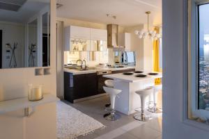 a white kitchen with a counter and stools at Golden-Hour Loft 35F Sunset Views Free Parking in Gorno Lisiče