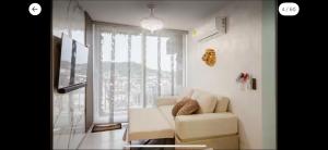 a living room with a white couch and a large window at Apto refugio del mar in Cartagena de Indias