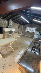 a large room with a table and a counter at Chacara dos Sonhos Votuporanga in Votuporanga +15 photos